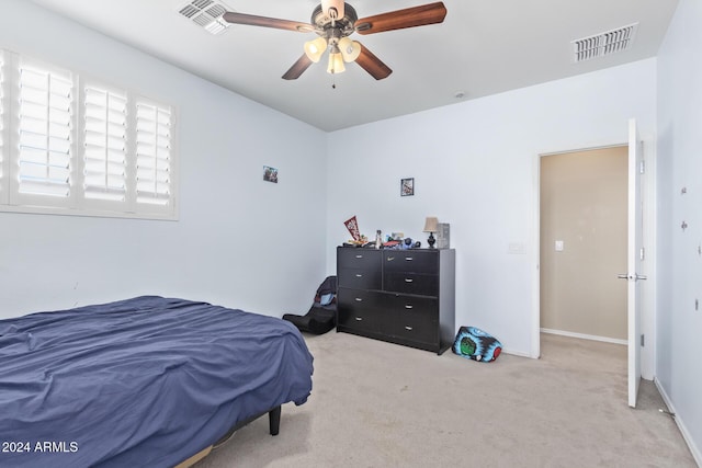 carpeted bedroom with visible vents, baseboards, and ceiling fan