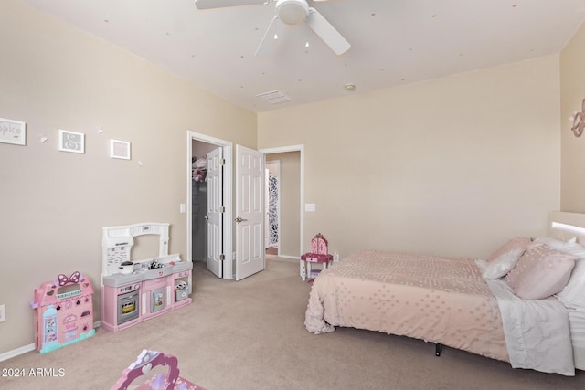 carpeted bedroom with a spacious closet, visible vents, and ceiling fan