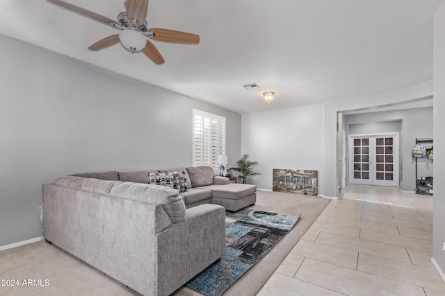 living room featuring tile patterned floors, baseboards, visible vents, and ceiling fan