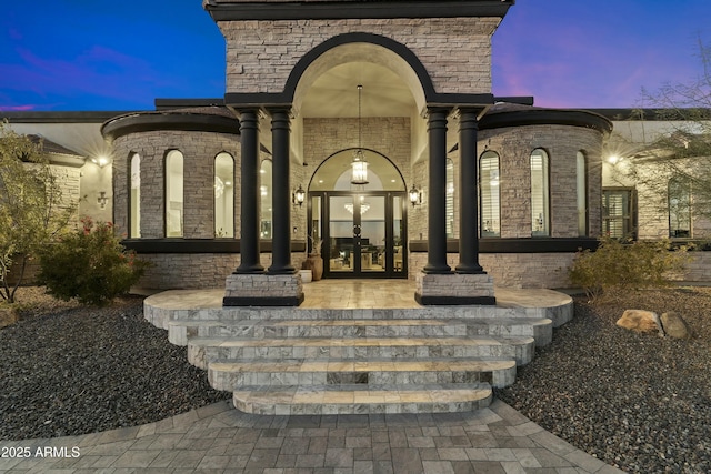 exterior entry at dusk featuring french doors