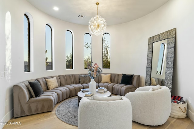 living room featuring a chandelier and light hardwood / wood-style flooring