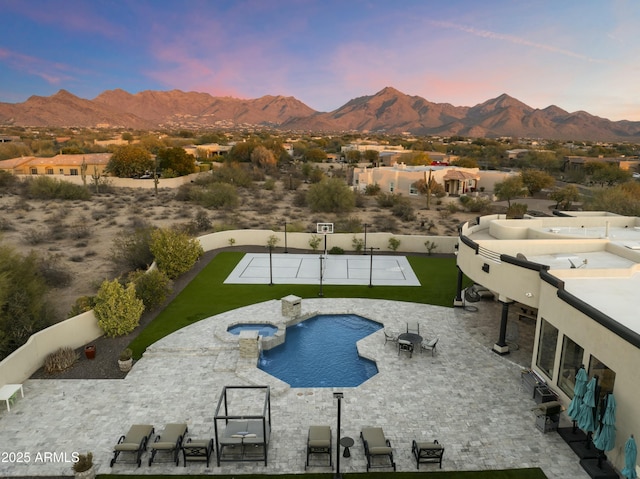 pool at dusk with a mountain view and a lawn