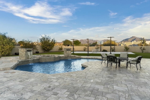 view of pool with pool water feature, a mountain view, and a patio