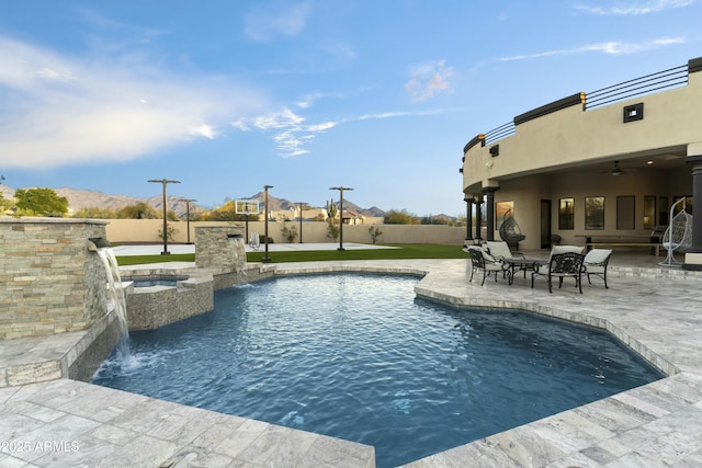 view of swimming pool with pool water feature, ceiling fan, an in ground hot tub, and a patio