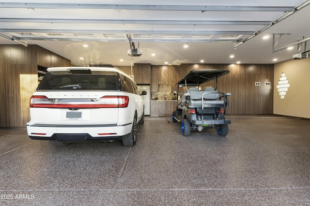 garage with wood walls and a garage door opener