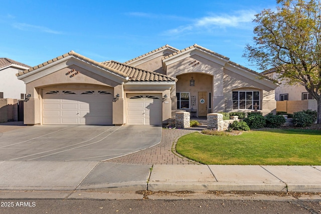 mediterranean / spanish home with a garage, driveway, a tiled roof, stucco siding, and a front lawn