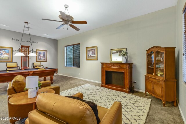 carpeted living area with a fireplace, baseboards, a ceiling fan, and pool table