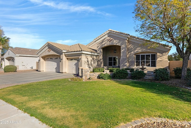 mediterranean / spanish house featuring a front yard, driveway, an attached garage, and stucco siding