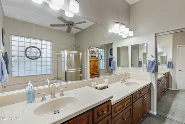 full bath featuring ceiling fan, double vanity, a sink, and a shower stall