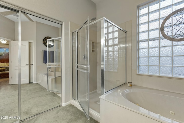 full bathroom featuring ceiling fan, a shower stall, and a tub with jets