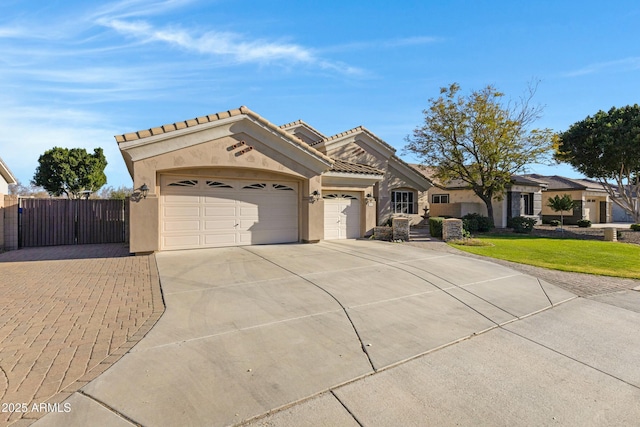 view of front of property with concrete driveway, a tiled roof, an attached garage, fence, and stucco siding