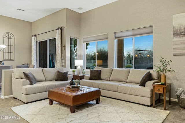 carpeted living room with visible vents and baseboards