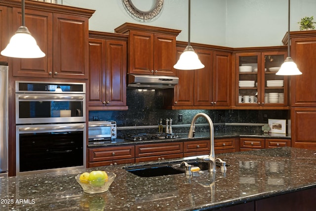 kitchen featuring stainless steel appliances, backsplash, a sink, and under cabinet range hood