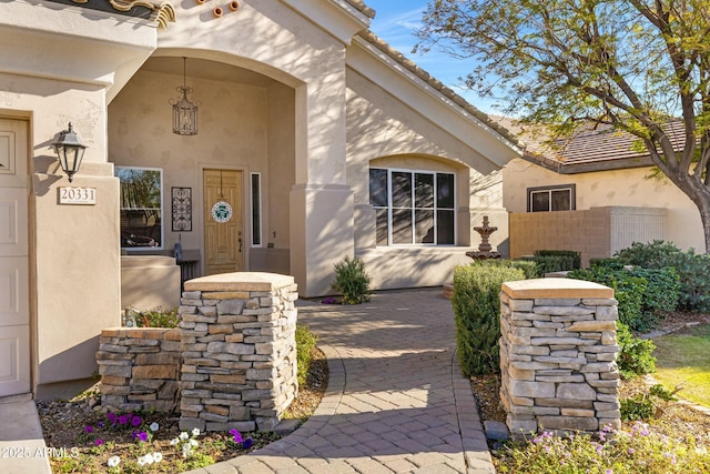 doorway to property featuring a tile roof and stucco siding