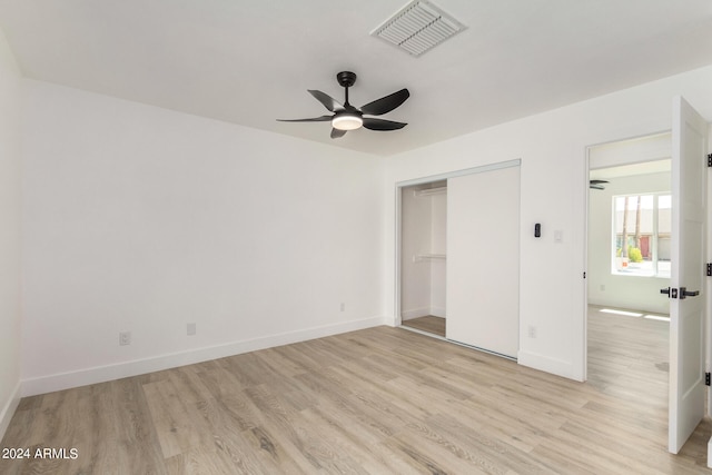 unfurnished bedroom featuring light wood-type flooring, ceiling fan, and a closet