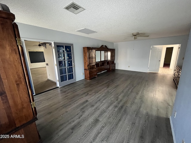 unfurnished living room with dark hardwood / wood-style flooring, a textured ceiling, and ceiling fan