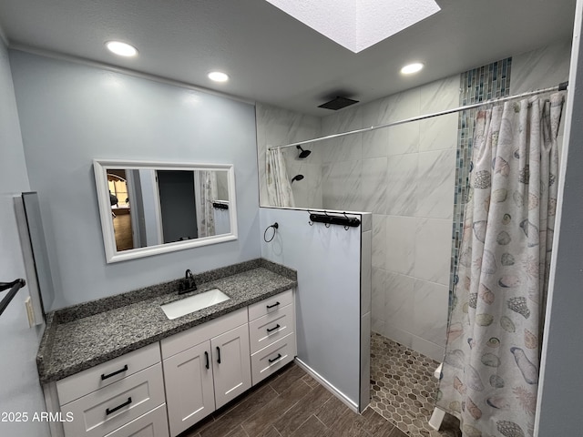 bathroom with a skylight, vanity, and curtained shower