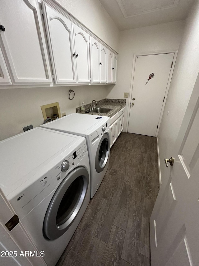 laundry area featuring separate washer and dryer, sink, dark hardwood / wood-style floors, and cabinets