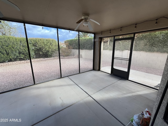 unfurnished sunroom featuring ceiling fan