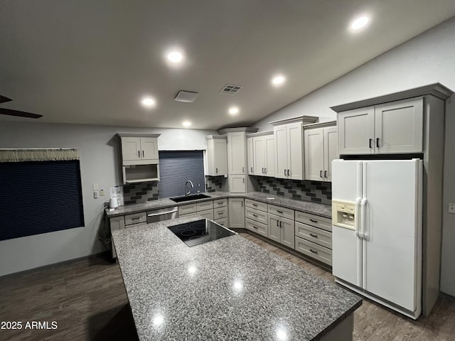 kitchen featuring white refrigerator with ice dispenser, sink, black electric cooktop, and dark hardwood / wood-style floors