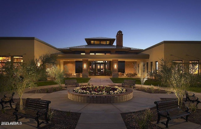 back of property with stucco siding and a chimney