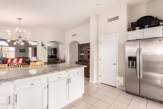 kitchen featuring decorative light fixtures, white cabinetry, a chandelier, stainless steel fridge with ice dispenser, and light stone countertops