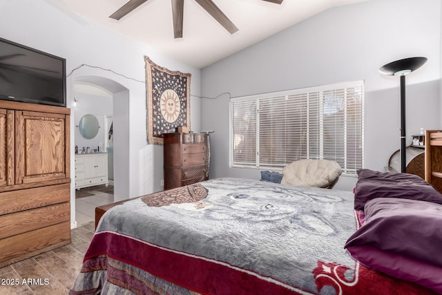 bedroom featuring lofted ceiling, light hardwood / wood-style flooring, ceiling fan, and ensuite bathroom