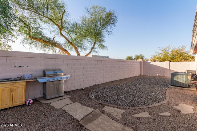 view of yard featuring an outdoor kitchen and central air condition unit