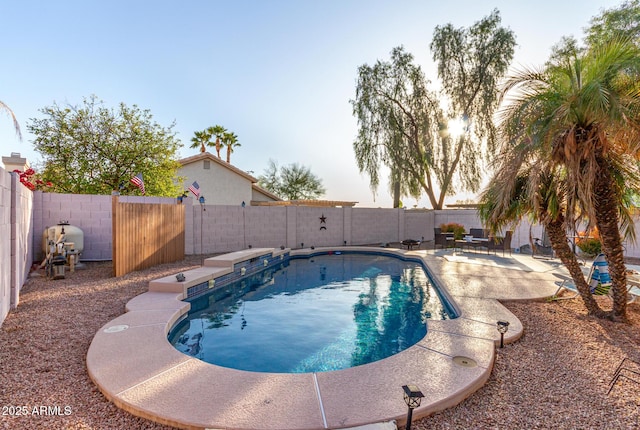 pool at dusk with a patio area