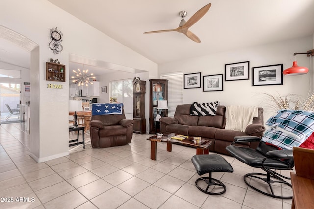 living room with ceiling fan with notable chandelier, lofted ceiling, and light tile patterned floors