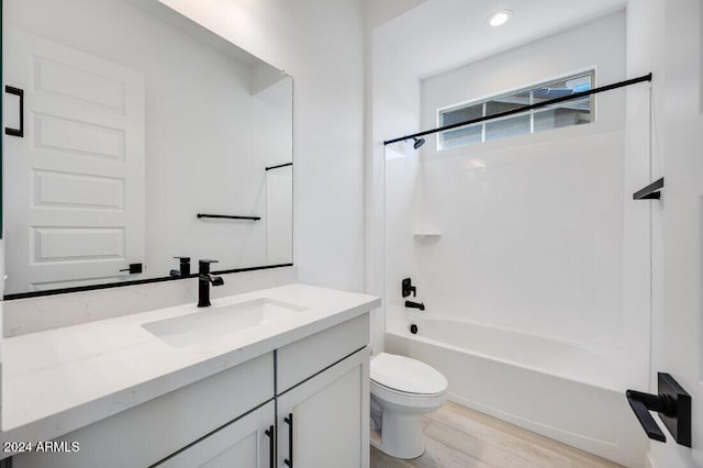 full bathroom featuring hardwood / wood-style flooring, vanity, toilet, and washtub / shower combination