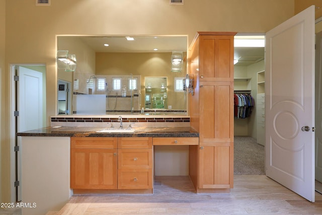 bathroom featuring a shower, decorative backsplash, and vanity