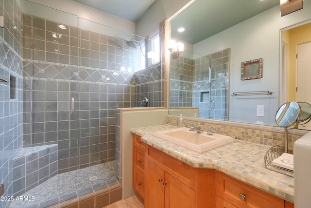 bathroom with vanity, walk in shower, and backsplash