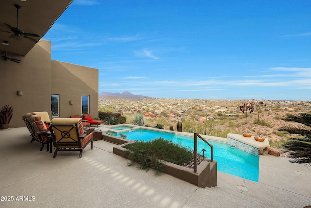 view of pool featuring an in ground hot tub, a mountain view, and a patio area