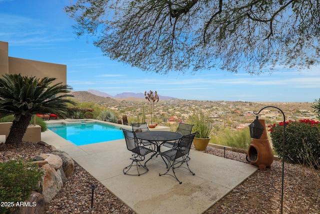 view of swimming pool with a patio area and a mountain view