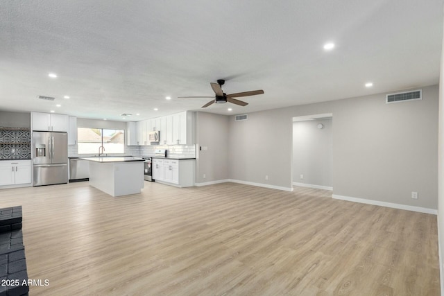 unfurnished living room featuring visible vents, baseboards, ceiling fan, light wood-type flooring, and recessed lighting