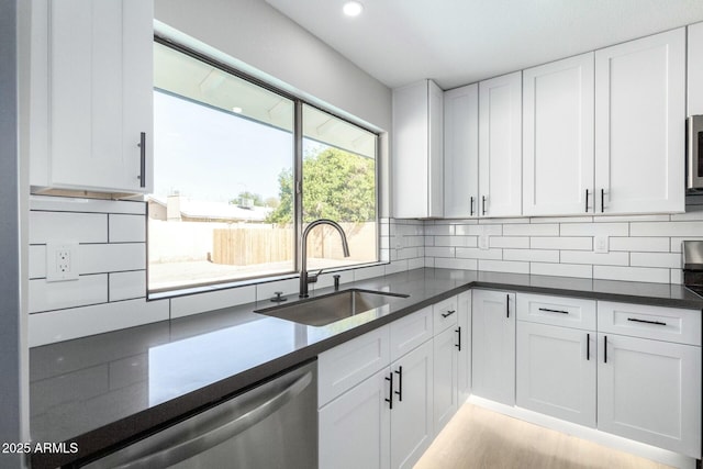 kitchen with white cabinetry, backsplash, and a sink