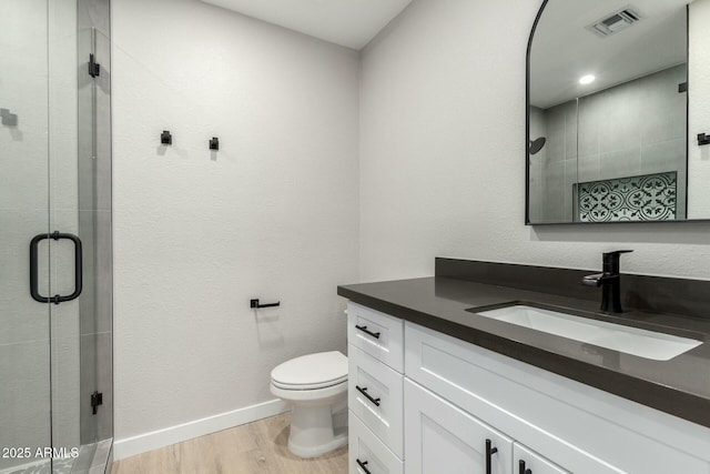 full bath featuring toilet, a shower stall, wood finished floors, and vanity