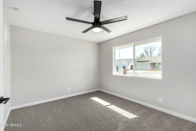 empty room featuring carpet flooring, a ceiling fan, and baseboards