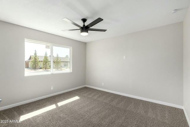 unfurnished room featuring a ceiling fan, dark carpet, and baseboards