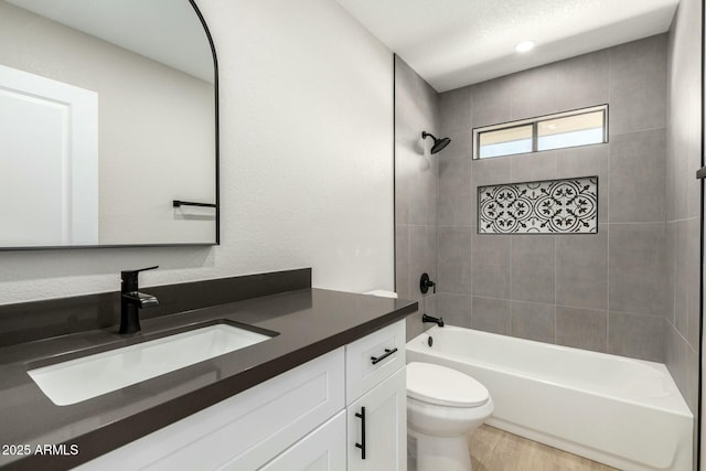 bathroom with wood finished floors, bathing tub / shower combination, toilet, and vanity