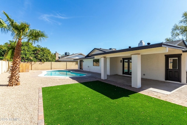 view of pool featuring a fenced in pool, french doors, a fenced backyard, a yard, and a patio area