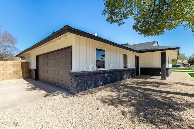 view of side of property featuring brick siding, driveway, and an attached garage