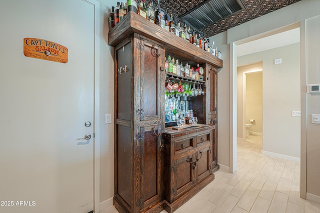 bar with baseboards, a bar, and visible vents