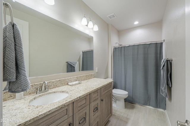full bathroom featuring vanity, a shower with curtain, toilet, and visible vents