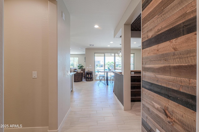 hallway with recessed lighting and baseboards