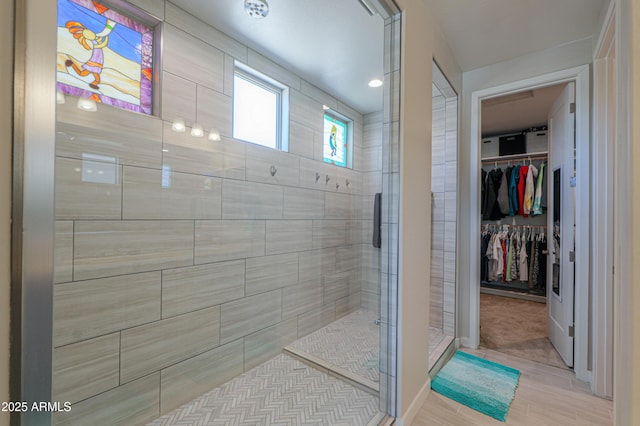 bathroom with a stall shower and a spacious closet