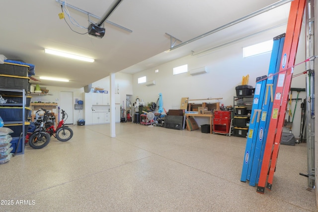 garage with a workshop area, a wall unit AC, and a garage door opener