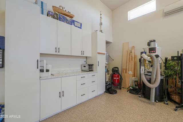 interior space with light speckled floor, a wall mounted AC, and a towering ceiling
