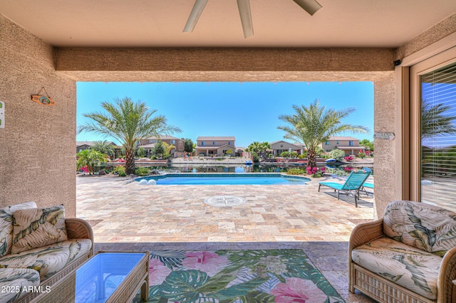 view of patio with a ceiling fan and an outdoor pool
